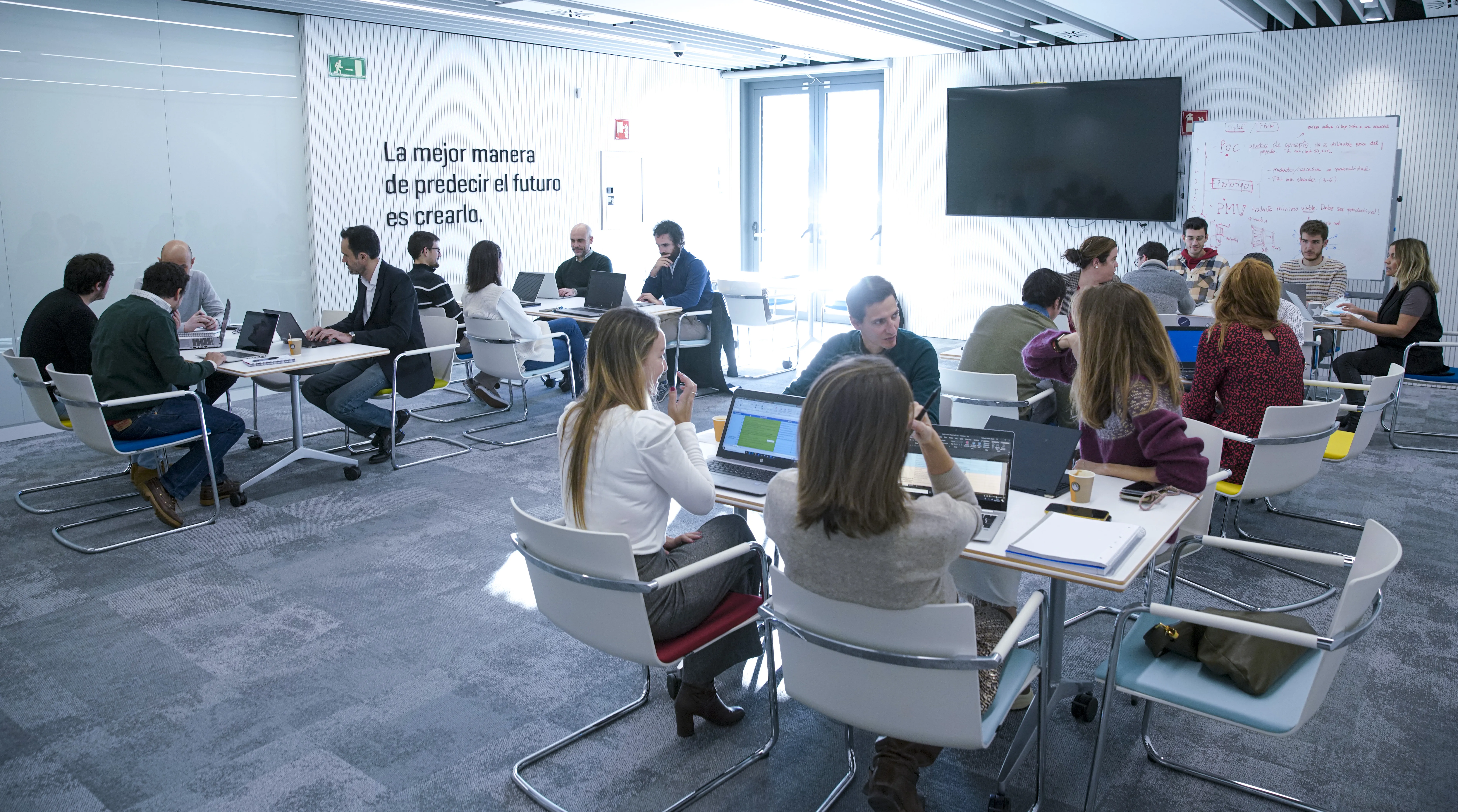People sitting at group tables in an office